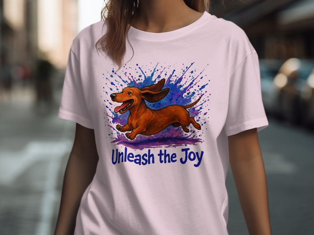 Brown dachshund running with colorful ink splatters and text "Unleash the Joy".