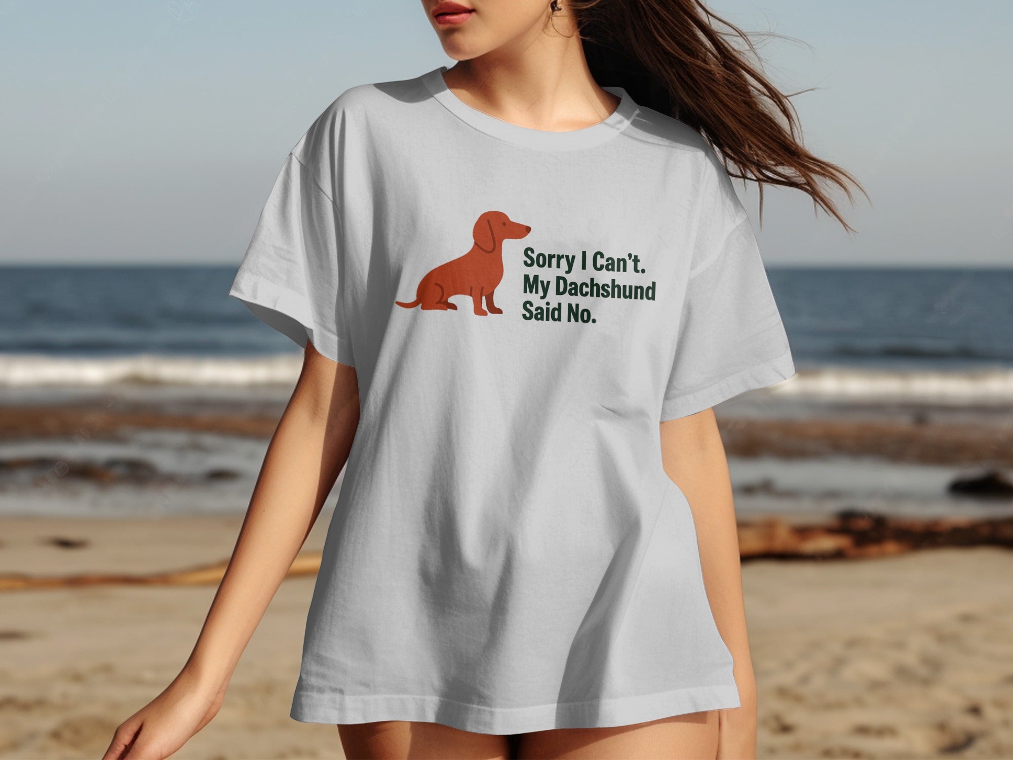 White t-shirt with a brown dachshund illustration and text that reads "Sorry I Can't. My Dachshund Said No."