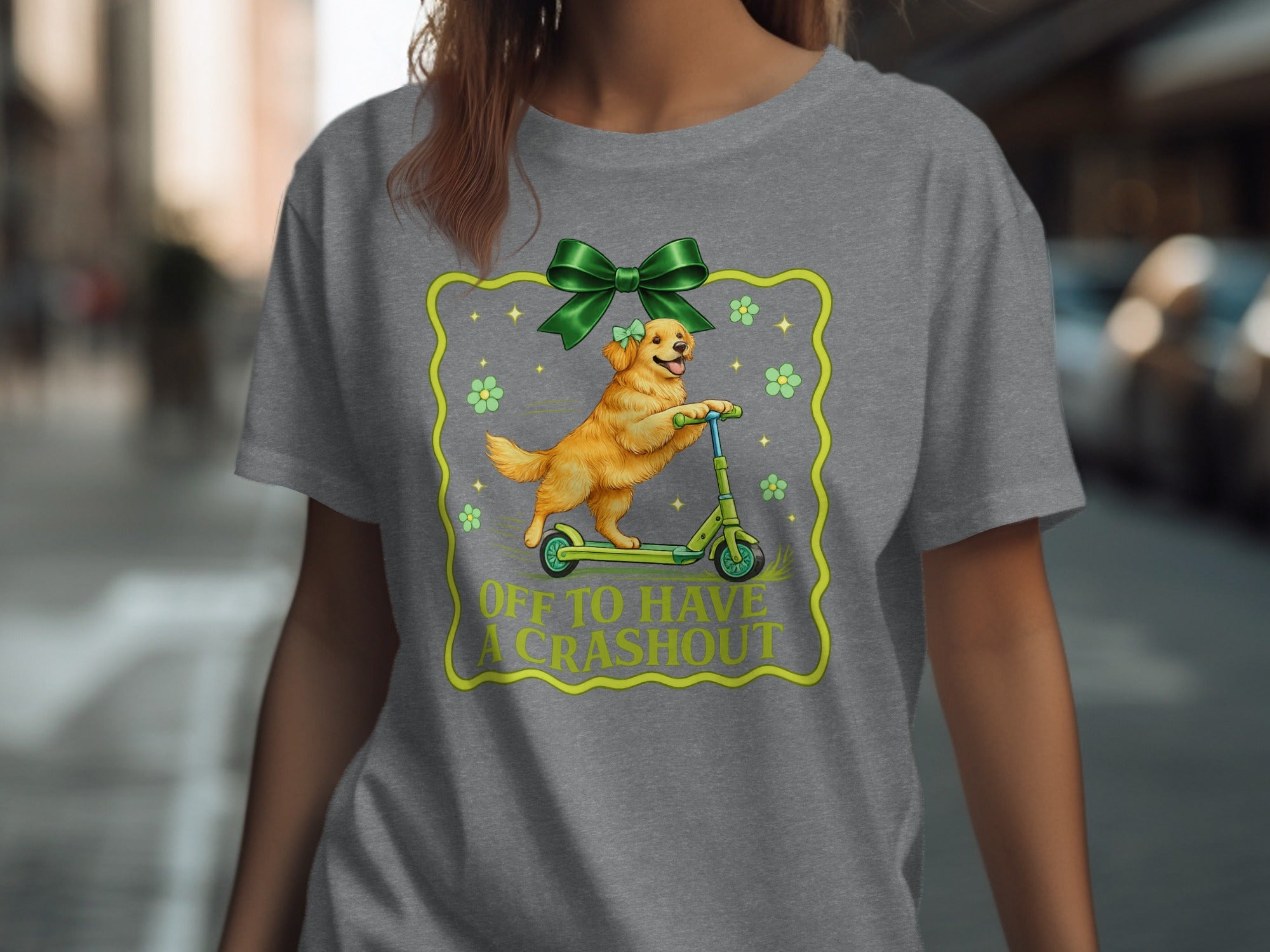 Golden retriever on a scooter with green bow and text "OFF TO HAVE A CRASHOUT".