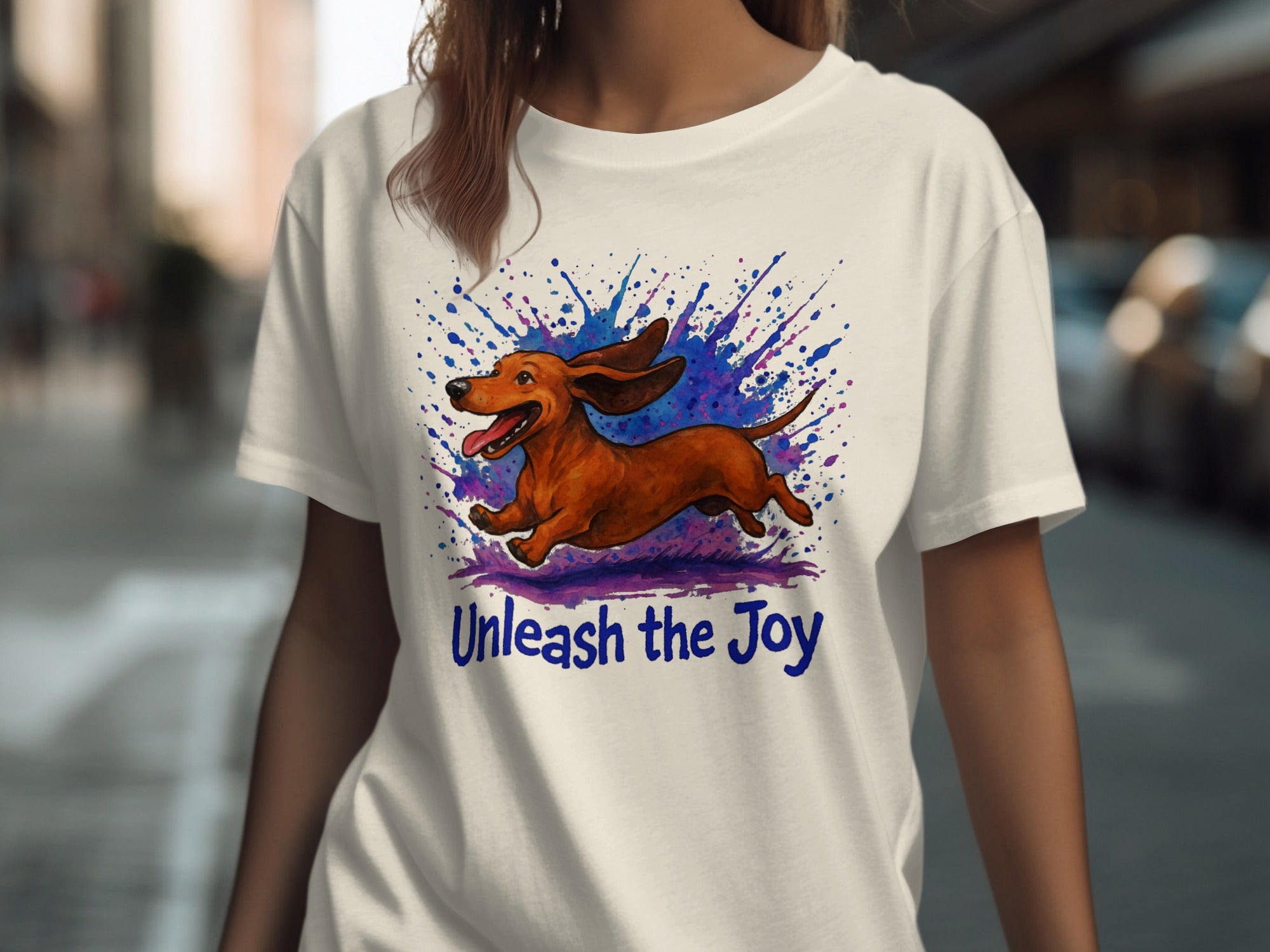 White t-shirt with leaping dachshund and blue purple watercolor splash. Unleash the Joy.