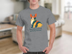 Grey t-shirt with a colorful graphic of a corgi and text "feral little creature, perfectly formed".