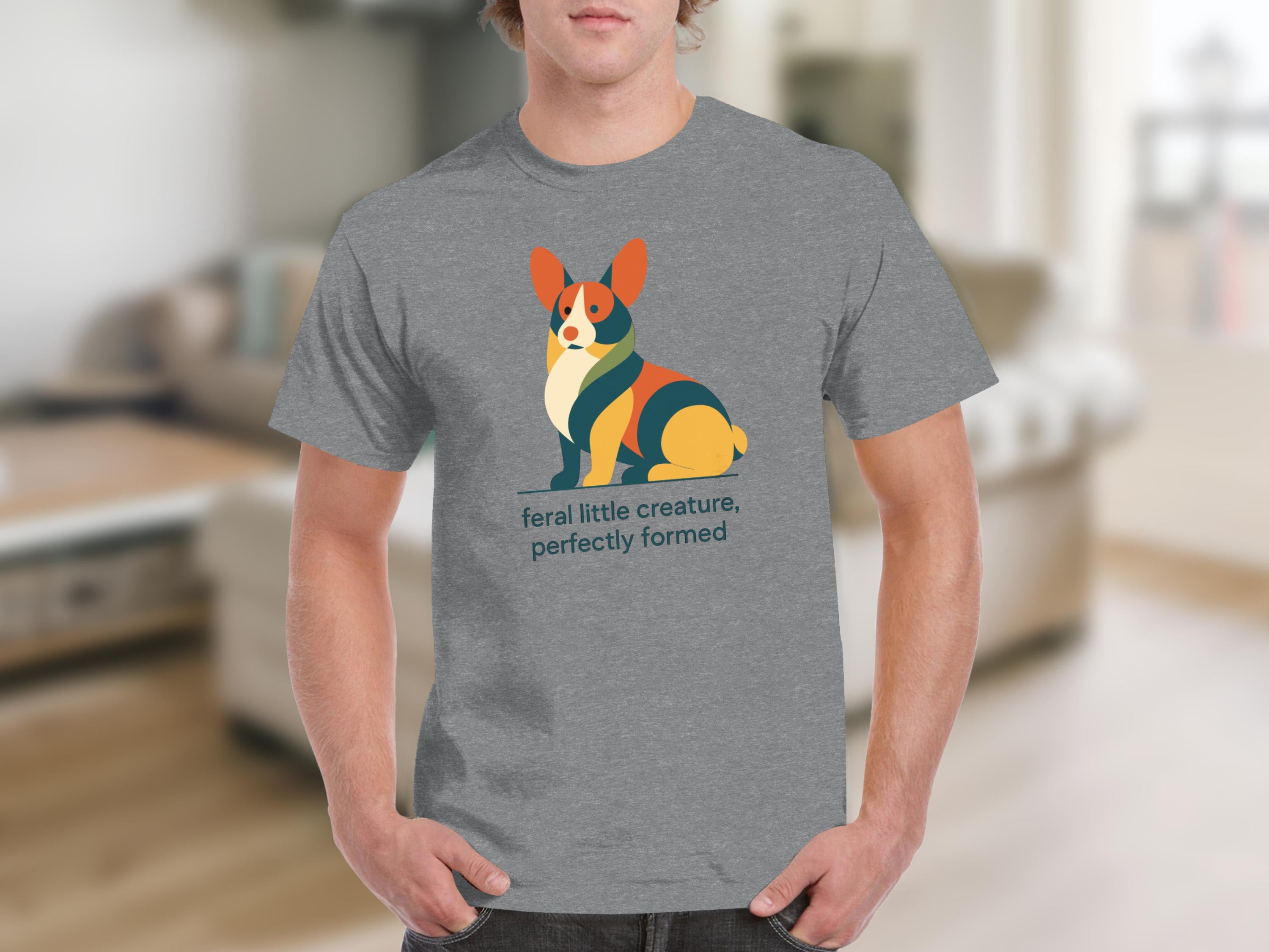 Grey t-shirt with a colorful graphic of a corgi and text "feral little creature, perfectly formed".