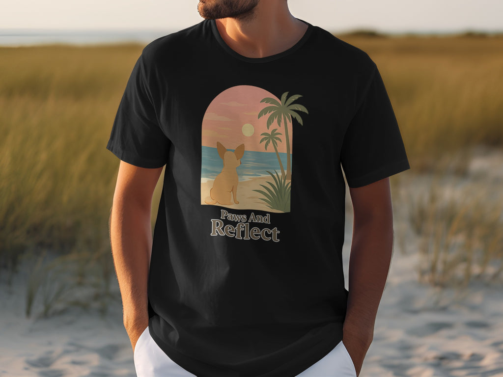 Black t-shirt with a French bulldog on a beach at sunset, "Paws And Reflect" text.