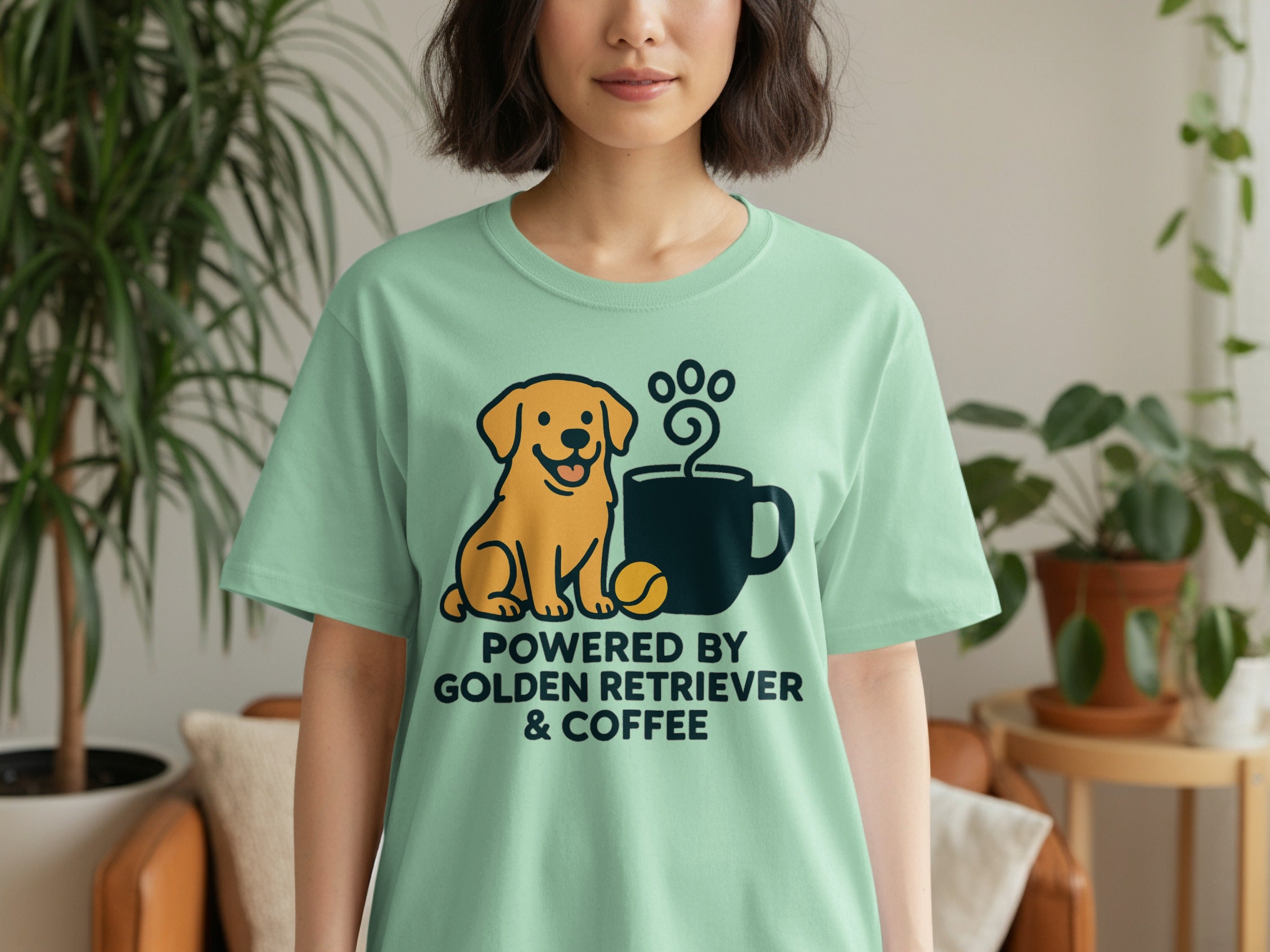 Light green t-shirt with a cartoon golden retriever, coffee cup, and text: Powered by Golden Retriever & Coffee.