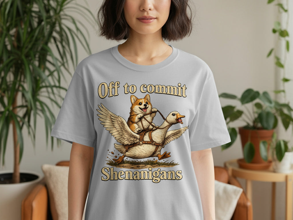 Grey t-shirt with a corgi riding a winged goose, text reads "Off to commit Shenanigans".