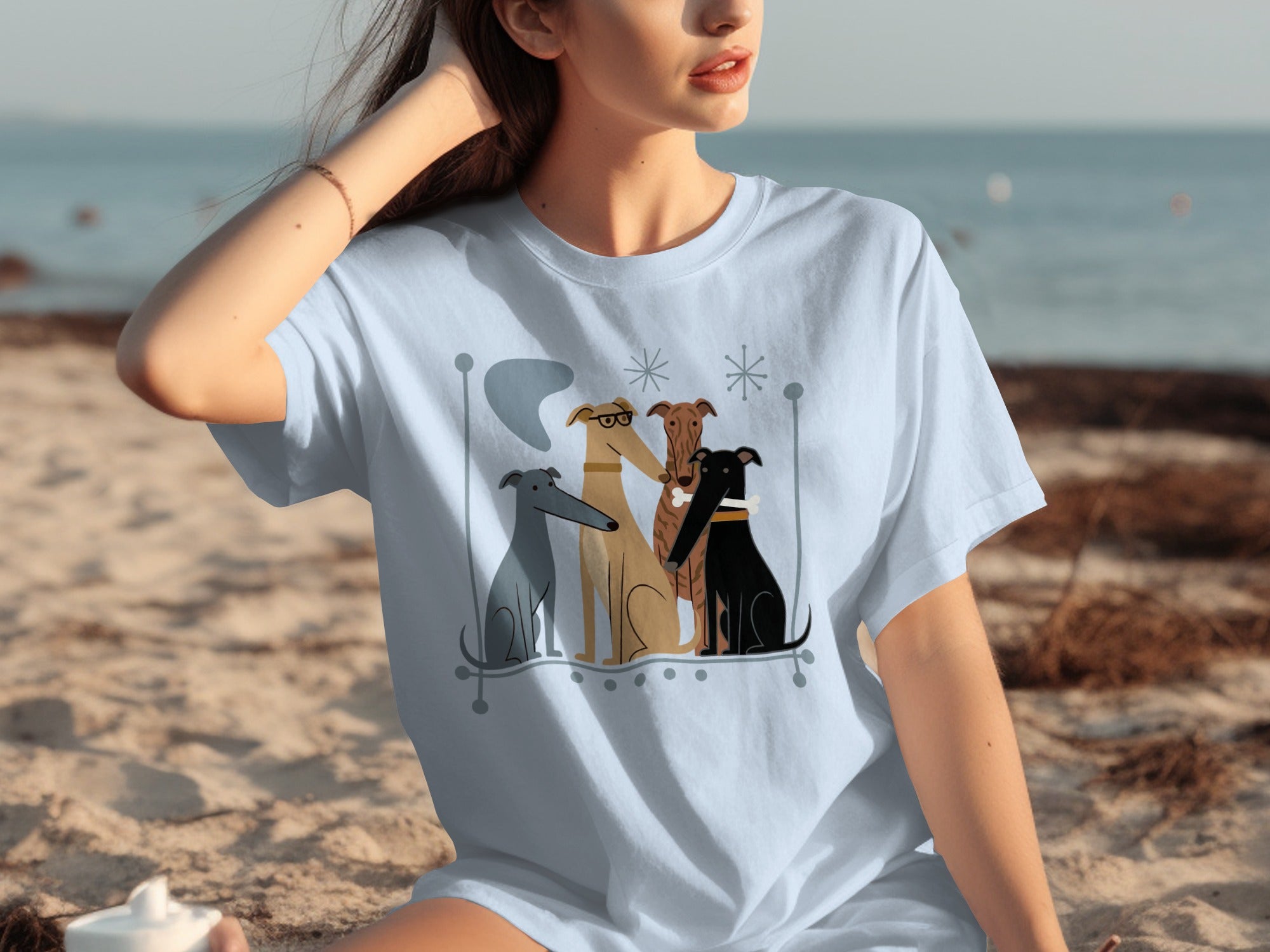 Light blue t-shirt with illustration of four greyhounds sitting together.