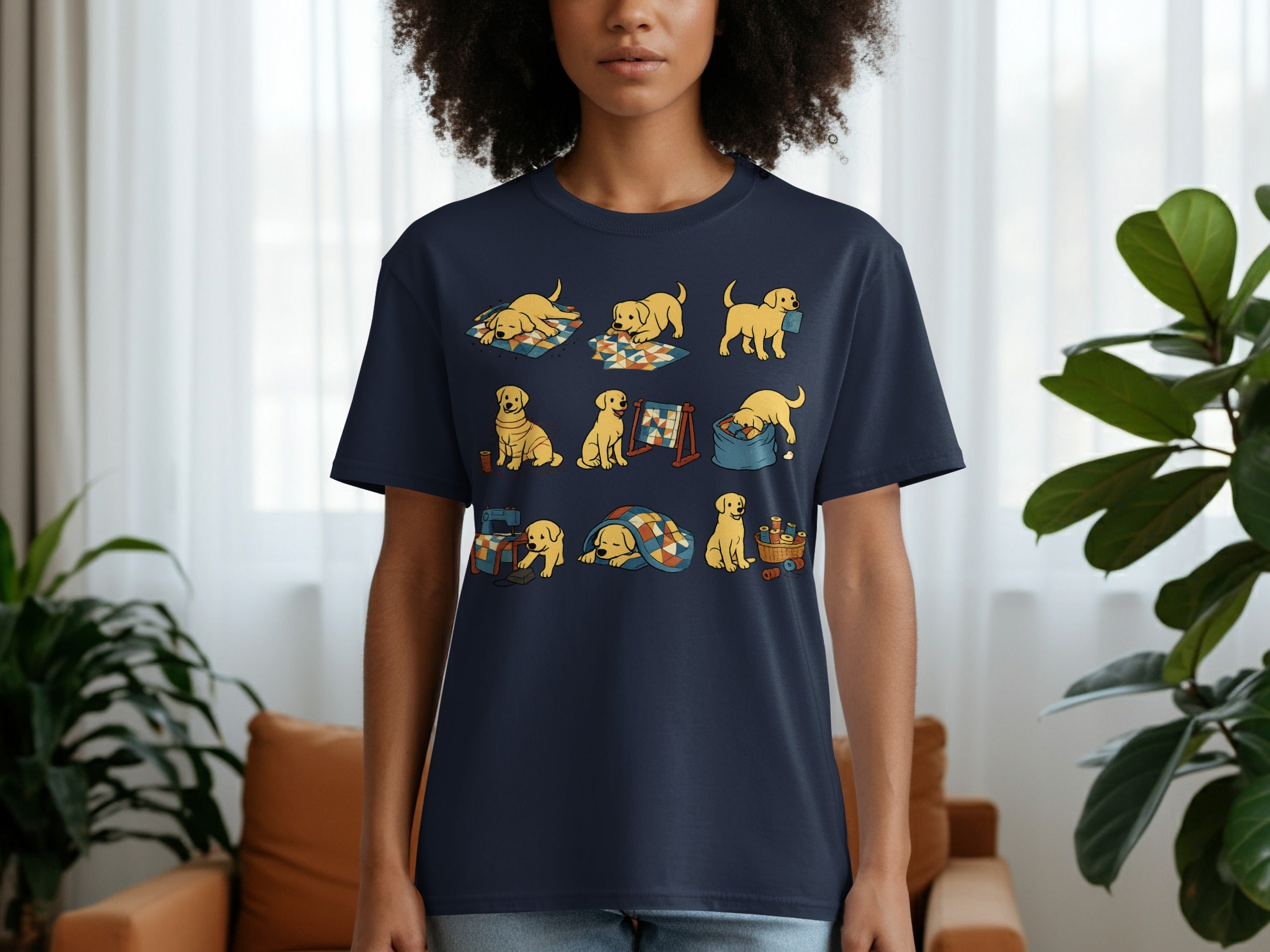 Dark blue t-shirt with a cartoon print of golden puppies sewing and playing with quilts.