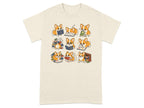 Nine illustrated corgis interacting with books in various poses on a cream t-shirt.