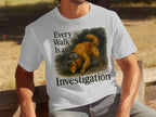 White t-shirt with illustration of golden retriever in deerstalker hat, text "Every Walk Is an Investigation".