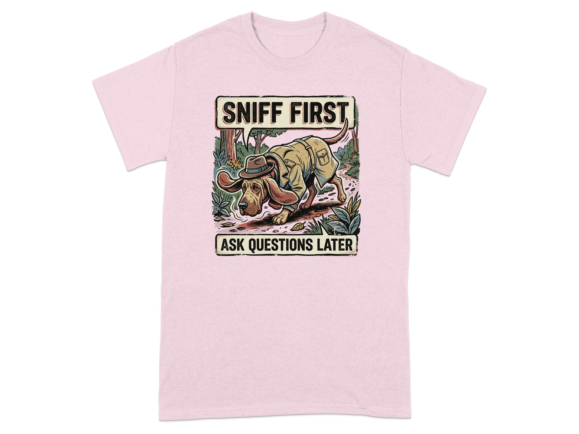 Pink t-shirt with cartoon dog wearing a hat and walking in woods, text "SNIFF FIRST ASK QUESTIONS LATER".