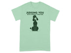 Green t-shirt with a poodle illustration and text "JUDGING YOU WITH PERFECT POSTURE".