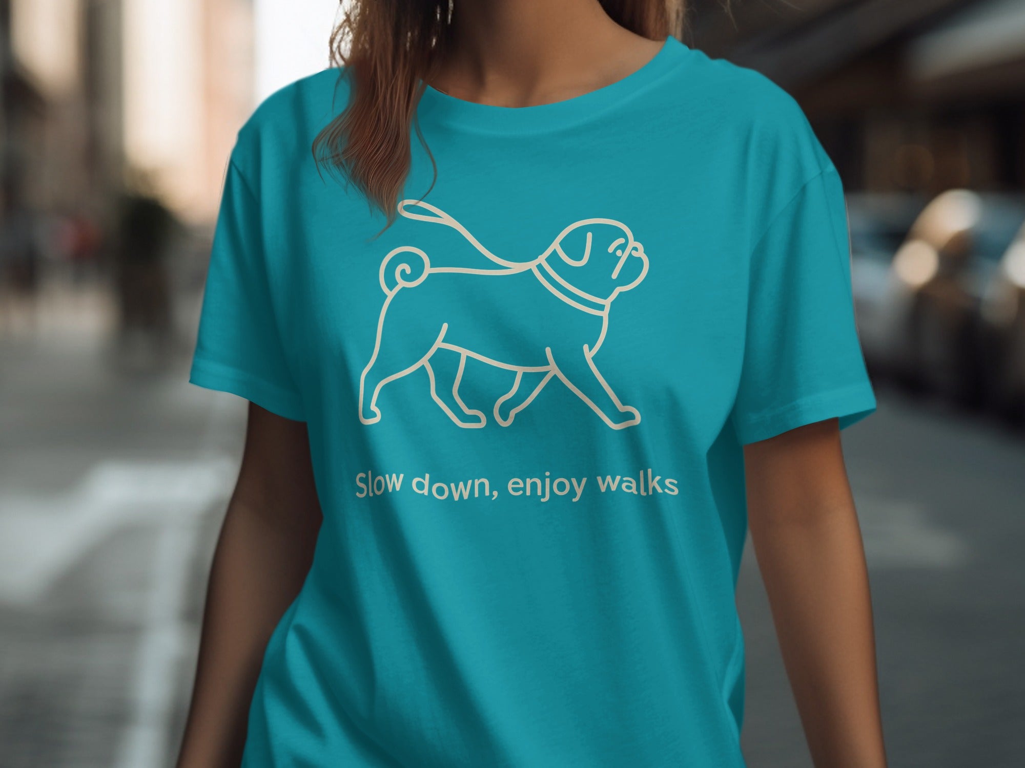 Teal t-shirt with outline of a pug and text "Slow down, enjoy walks"