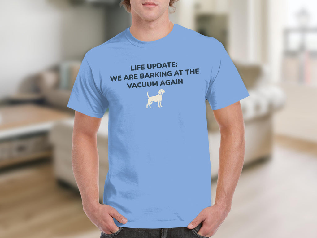 Light blue t-shirt with white text and dog graphic: "LIFE UPDATE: WE ARE BARKING AT THE VACUUM AGAIN".