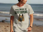 T-shirt with a dog's face and "STILLNESS IS DEEPLY SUSPICIOUS" text.
