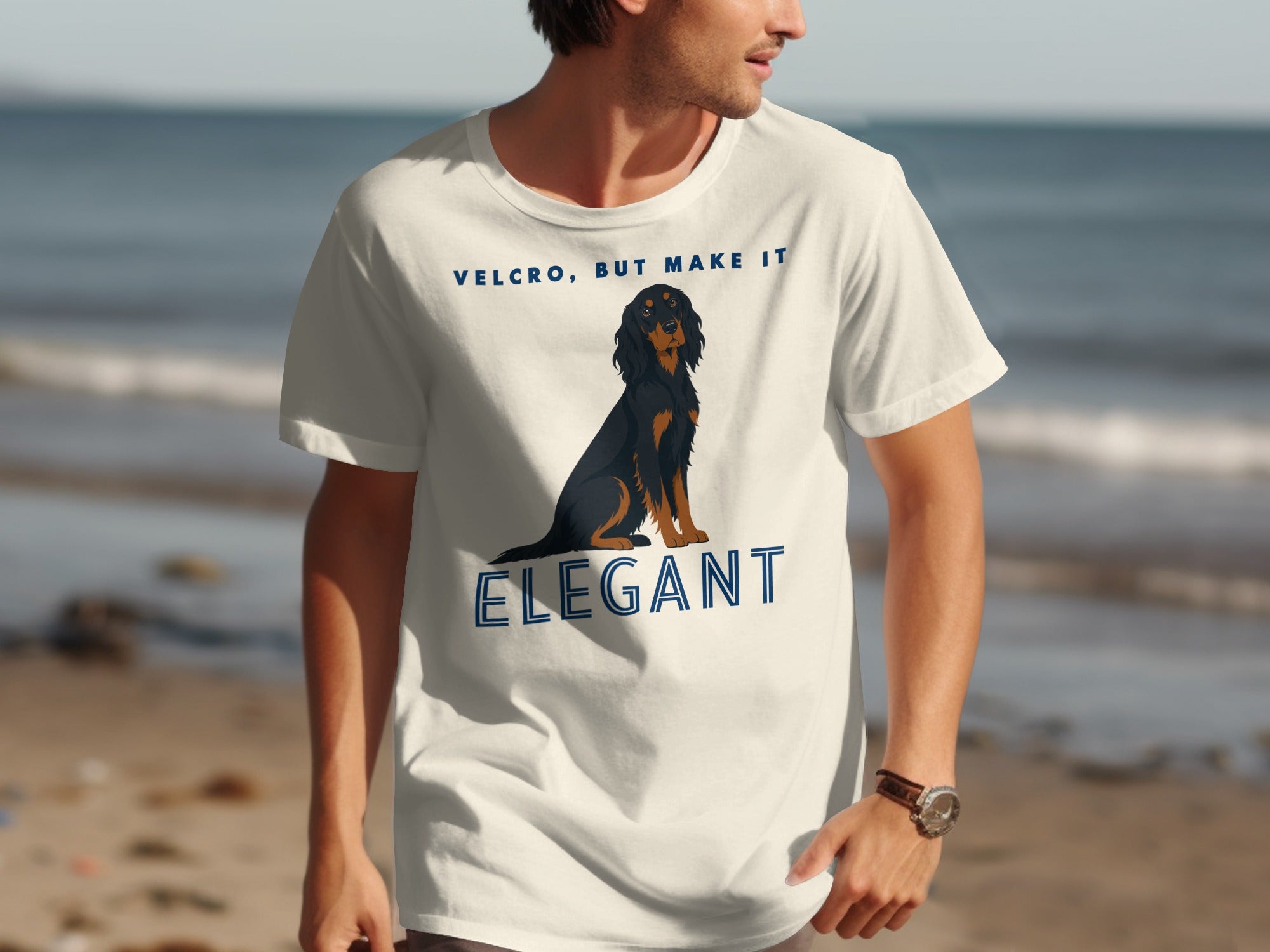 Man wearing a white t-shirt with a black and tan dachshund and text "Velcro, but make it Elegant".