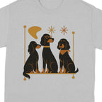 Three black dogs sit and look forward, one wearing glasses.