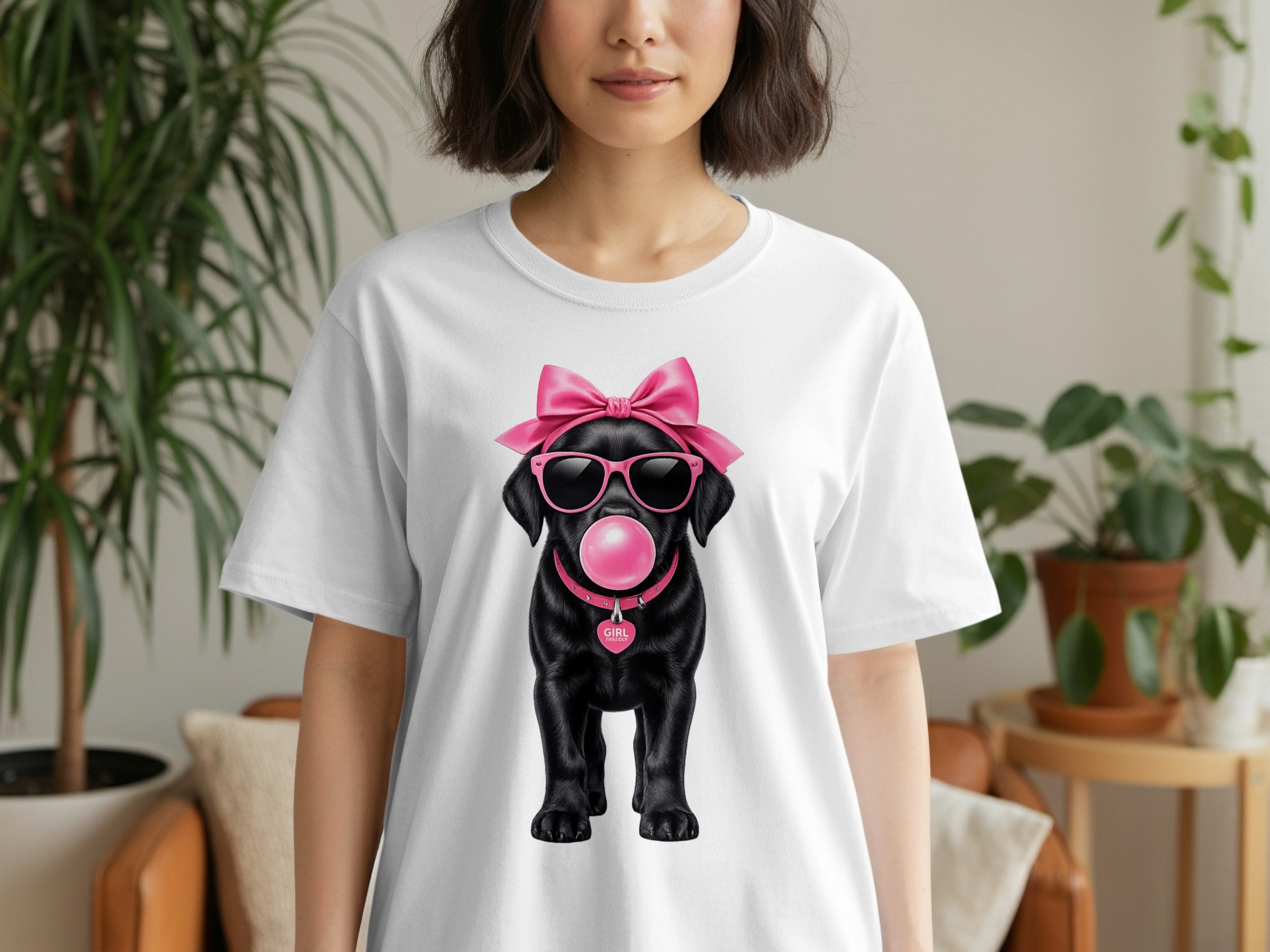 Black dog with pink sunglasses, bow, and bubblegum on white t-shirt.