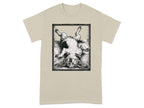 Black and white illustration of a dog lying on its back inside a framed rectangle on a tan t-shirt.
