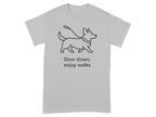 Light grey t-shirt with a line drawing of a dog on a leash and text saying "Slow down, enjoy walks."