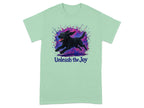 Mint t-shirt with black lab running through colorful paint splashes and text "Unleash the Joy."