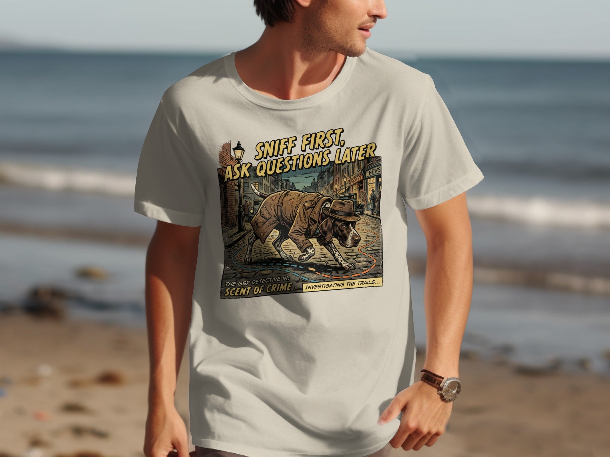 Beige t-shirt with graphic of a dog detective sniffing, text reads "Sniff First, Ask Questions Later".