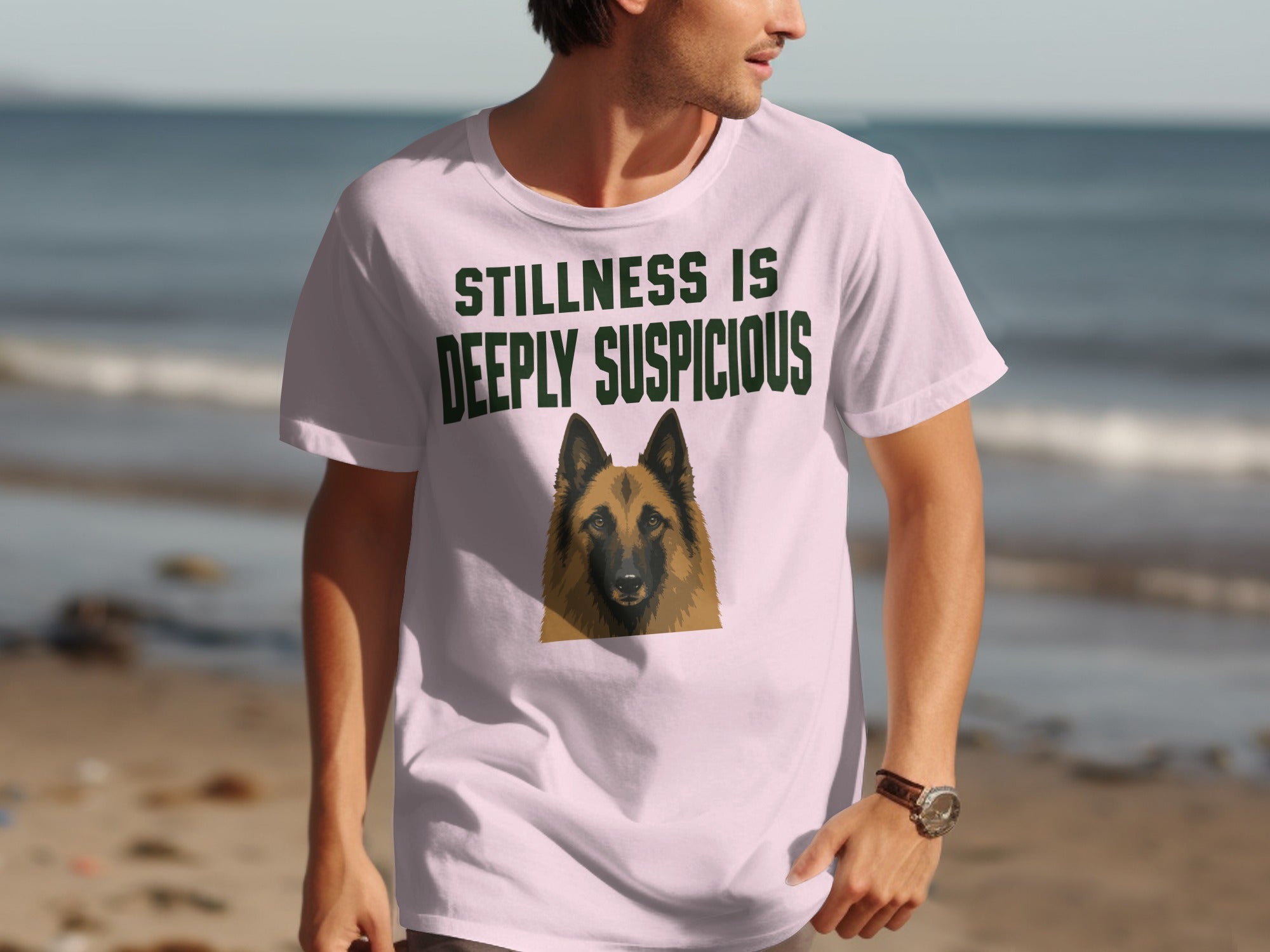 Light pink t-shirt with a German Shepherd graphic and text "STILLNESS IS DEEPLY SUSPICIOUS."
