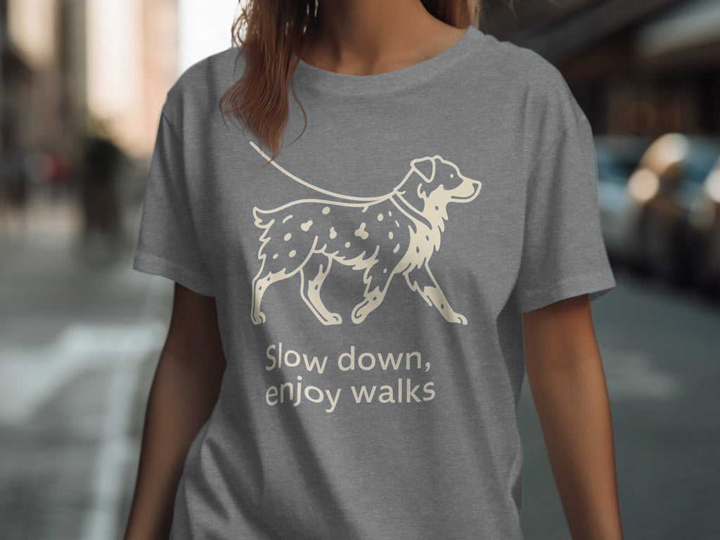 Grey t-shirt with line art of a dog on a leash and text "Slow down, enjoy walks".