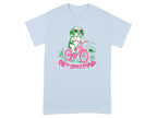 Light blue t-shirt with a cartoon dog riding a bicycle, wearing sunglasses.