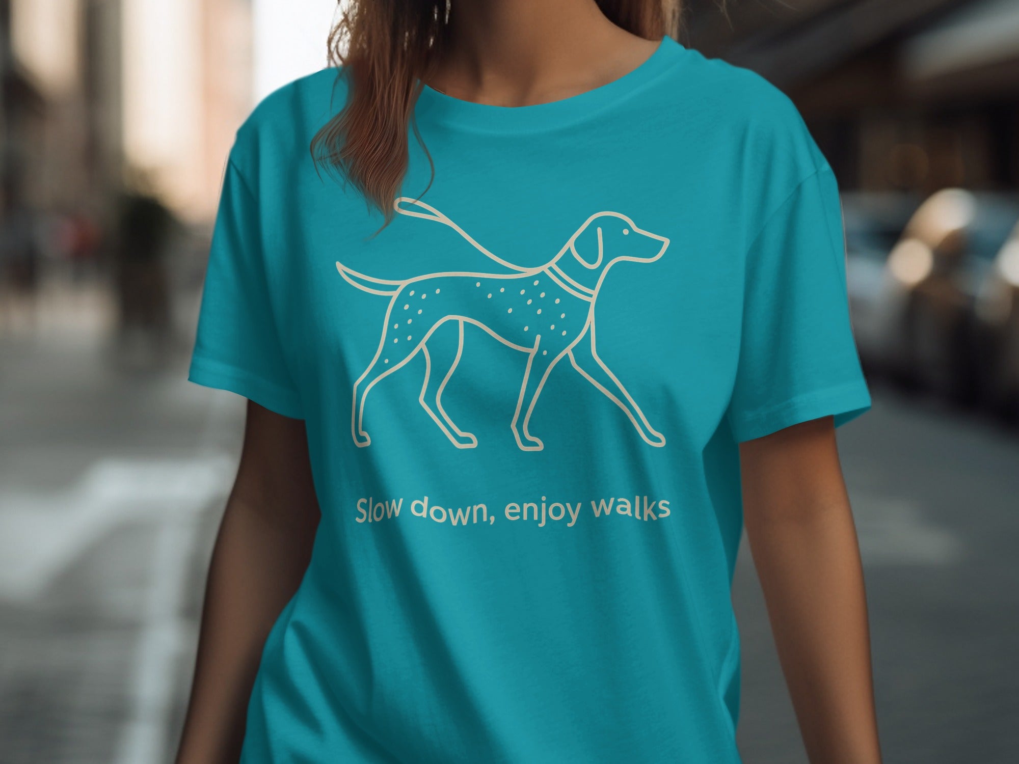 Teal t-shirt with a white line drawing of a dog and the text "Slow down, enjoy walks".