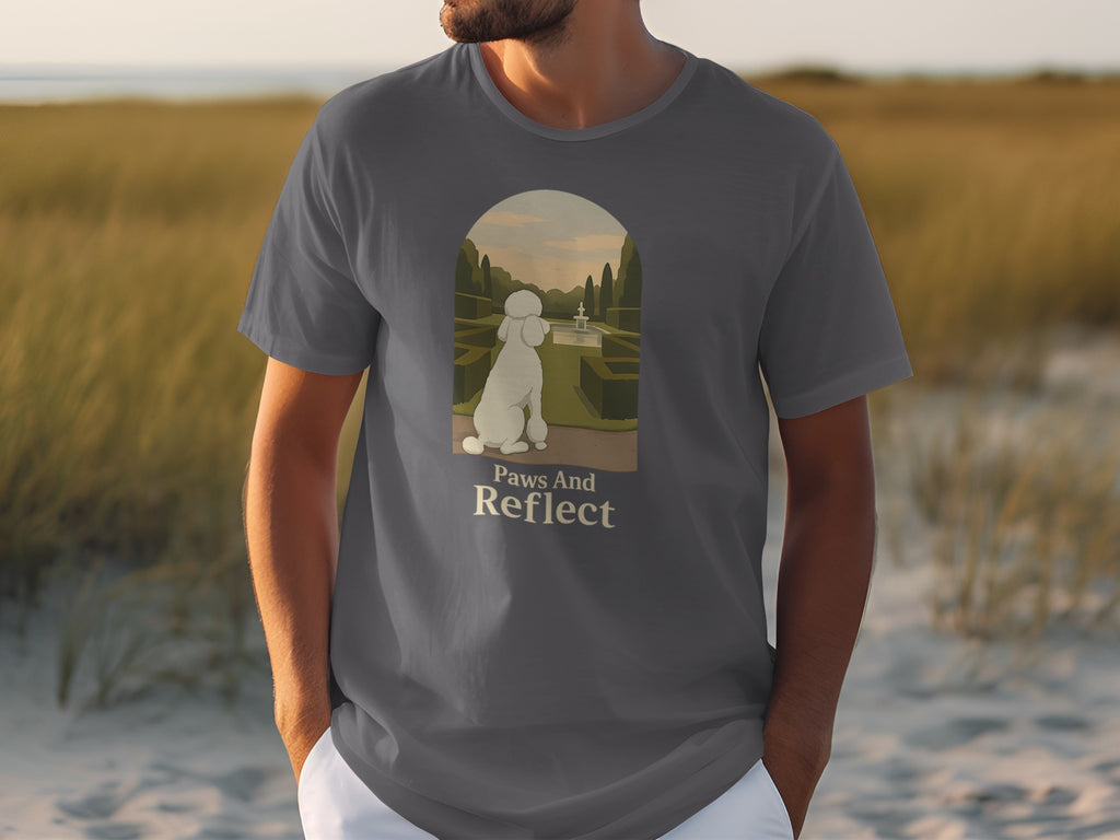 Grey t-shirt graphic of a poodle in a garden with text "Paws And Reflect".