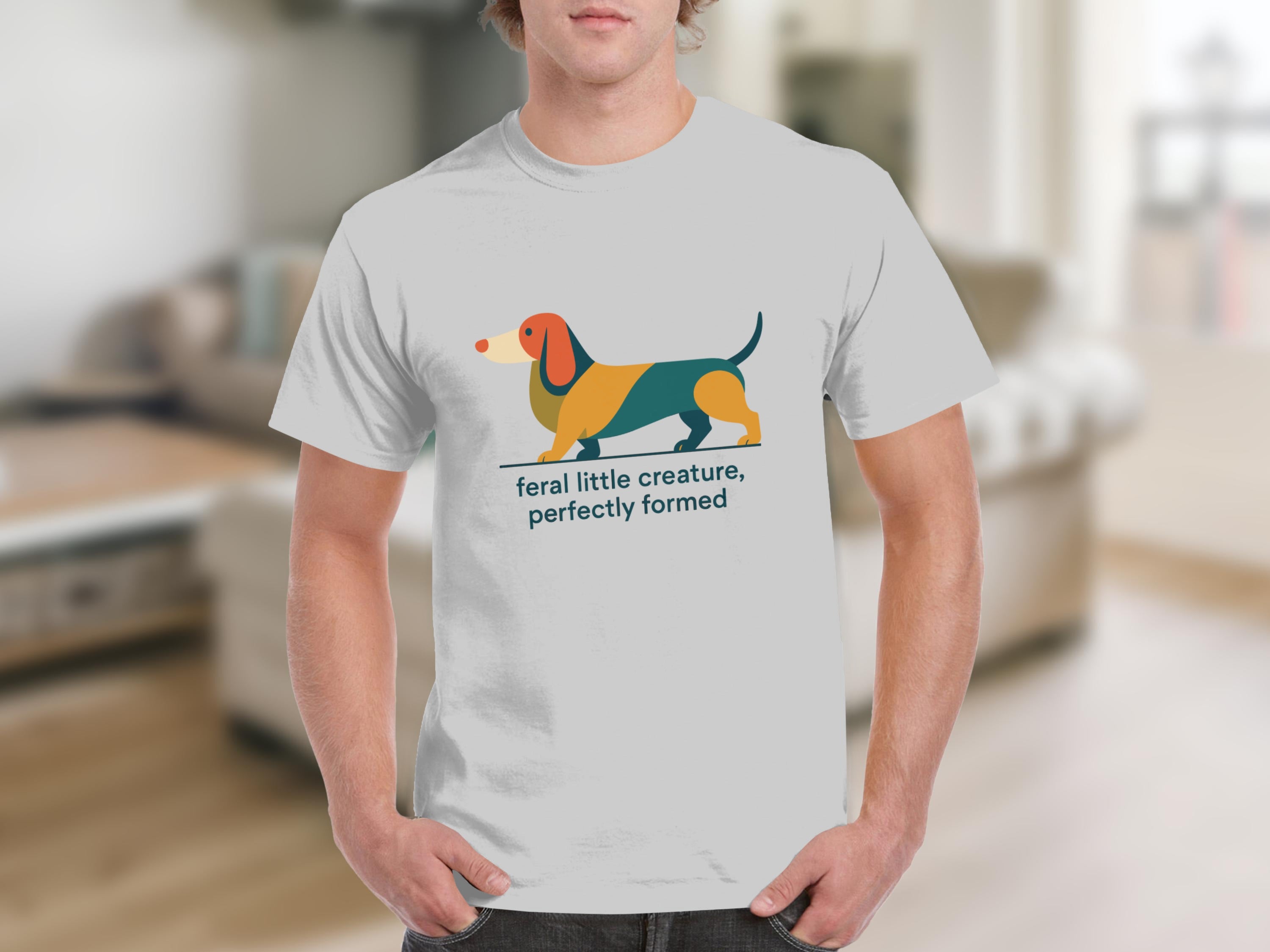 White t-shirt with graphic of a colorful dachshund and text "feral little creature, perfectly formed."
