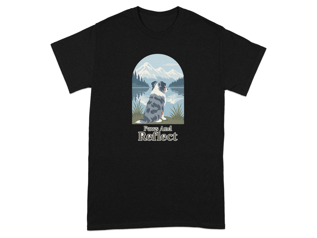 Black t-shirt with a blue merle dog looking at mountains over a lake. Text reads "Paws And Reflect".