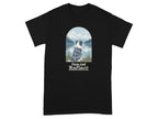 Black t-shirt with a blue merle dog looking at mountains over a lake. Text reads "Paws And Reflect".