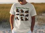 White t-shirt featuring nine cartoon dachshunds in various playful poses.