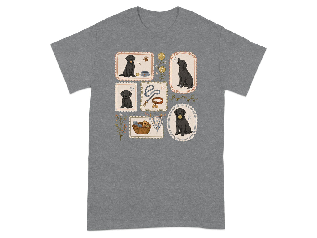 T-shirt with framed illustrations of black Labrador puppies playing and with accessories.