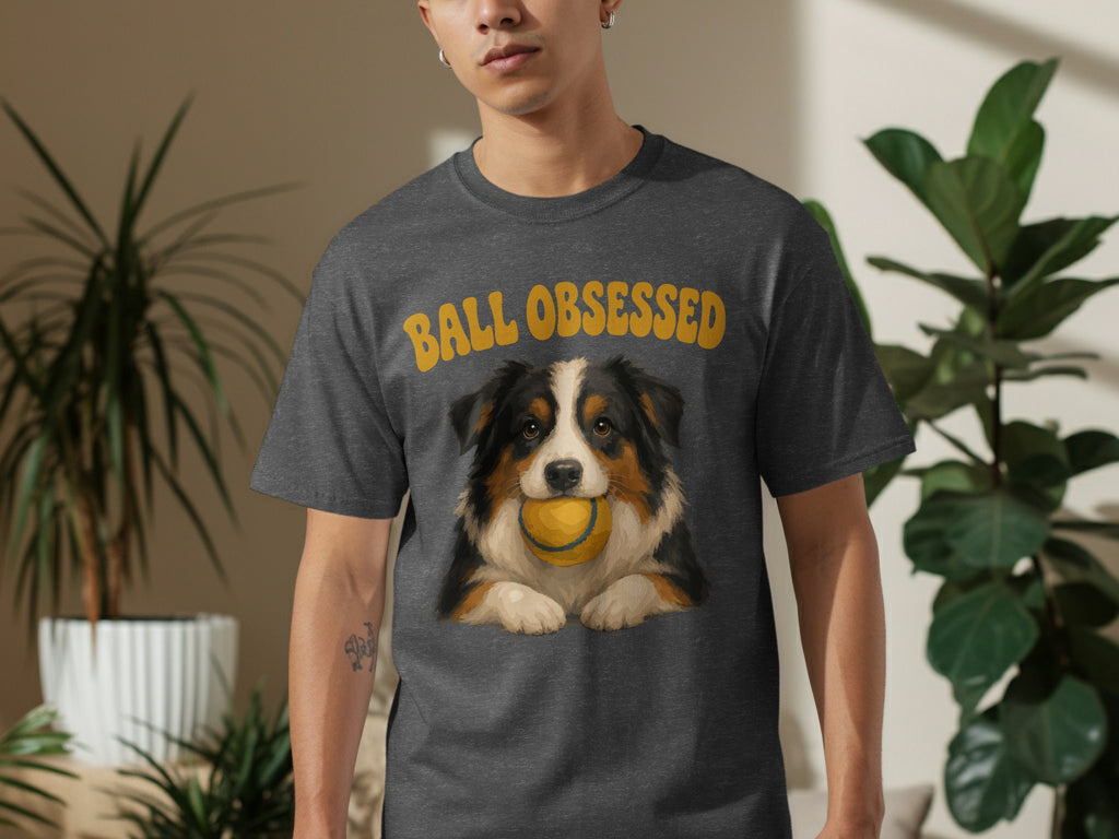 Man in dark grey t-shirt with dog and "Ball Obsessed" text.