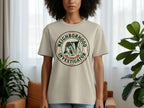 Beige t-shirt with "Neighborhood Investigator Service & Trust" emblem featuring a dog.