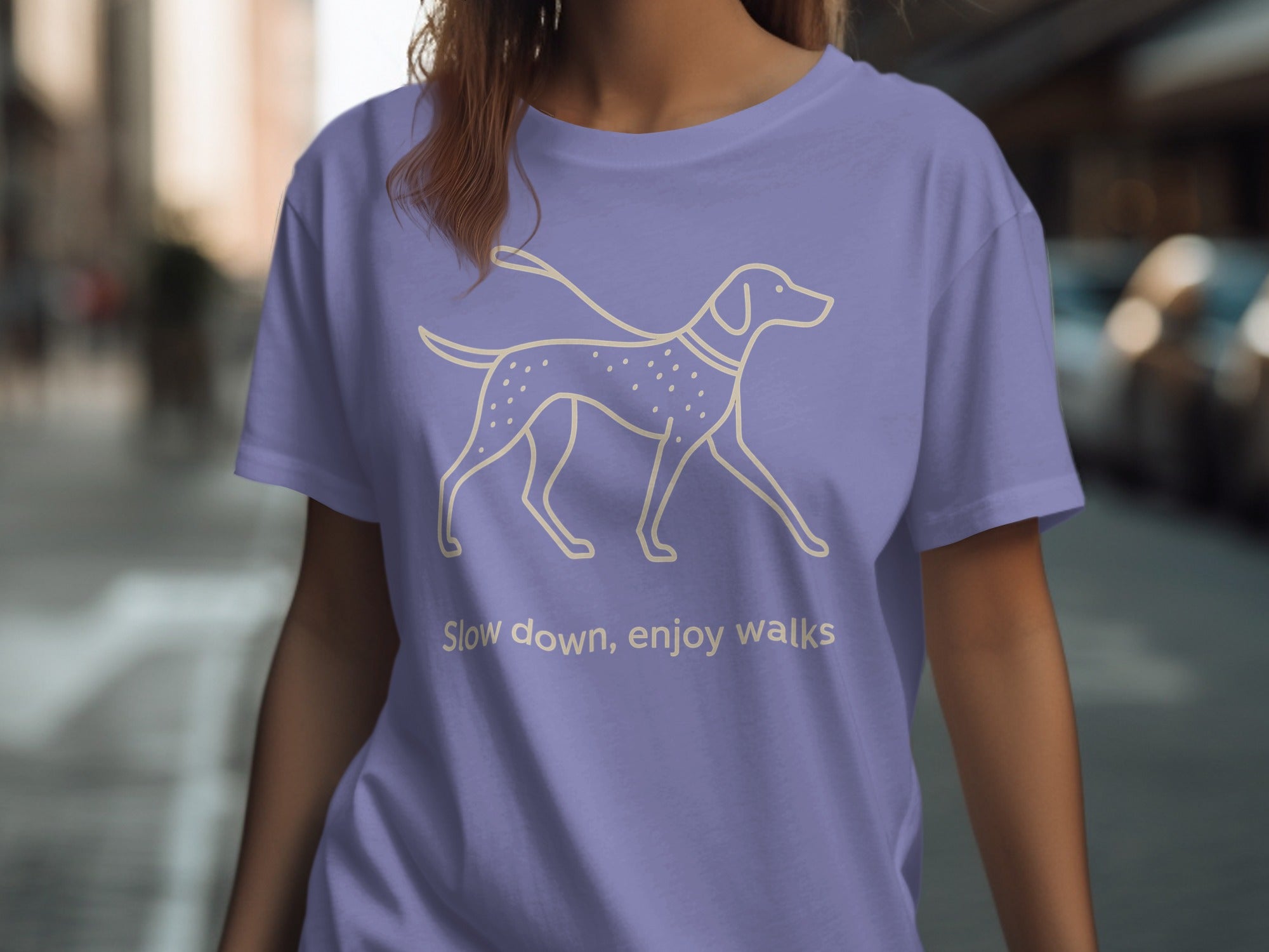 Purple t-shirt with a cream outline drawing of a dog and the text "Slow down, enjoy walks."