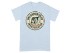 Light blue t-shirt with a circular graphic of a dog wearing a hat, labeled "Neighborhood Investigator."