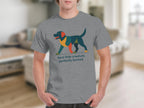 Grey t-shirt with abstract multi-colored dog and text "feral little creature, perfectly formed".