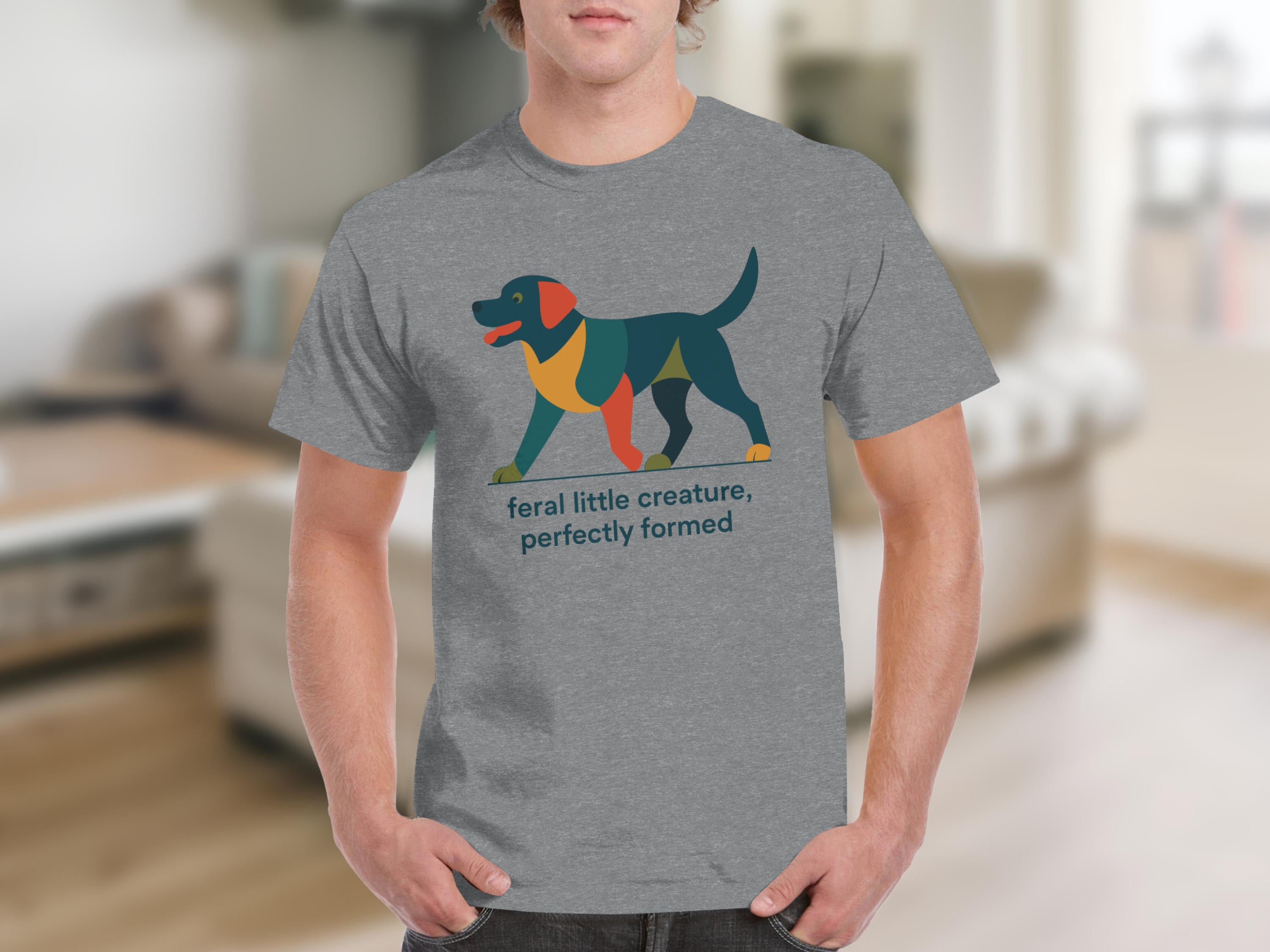Grey t-shirt with abstract multi-colored dog and text "feral little creature, perfectly formed".