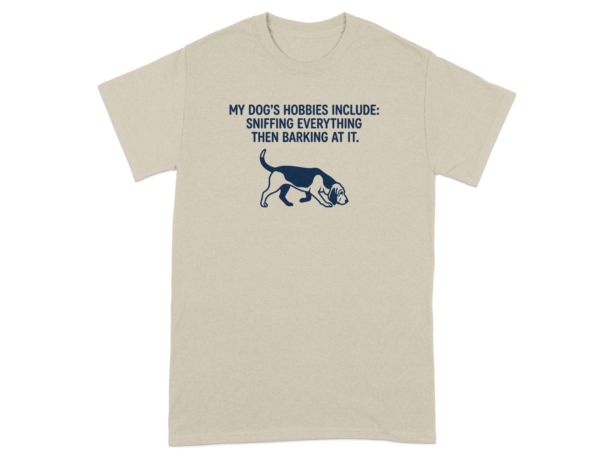 Tan t-shirt with dark blue text and dog graphic saying "MY DOG'S HOBBIES INCLUDE: SNIFFING EVERYTHING THEN BARKING AT IT."