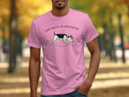 Pink t-shirt with a cartoon dog on a leash investigating paw prints.