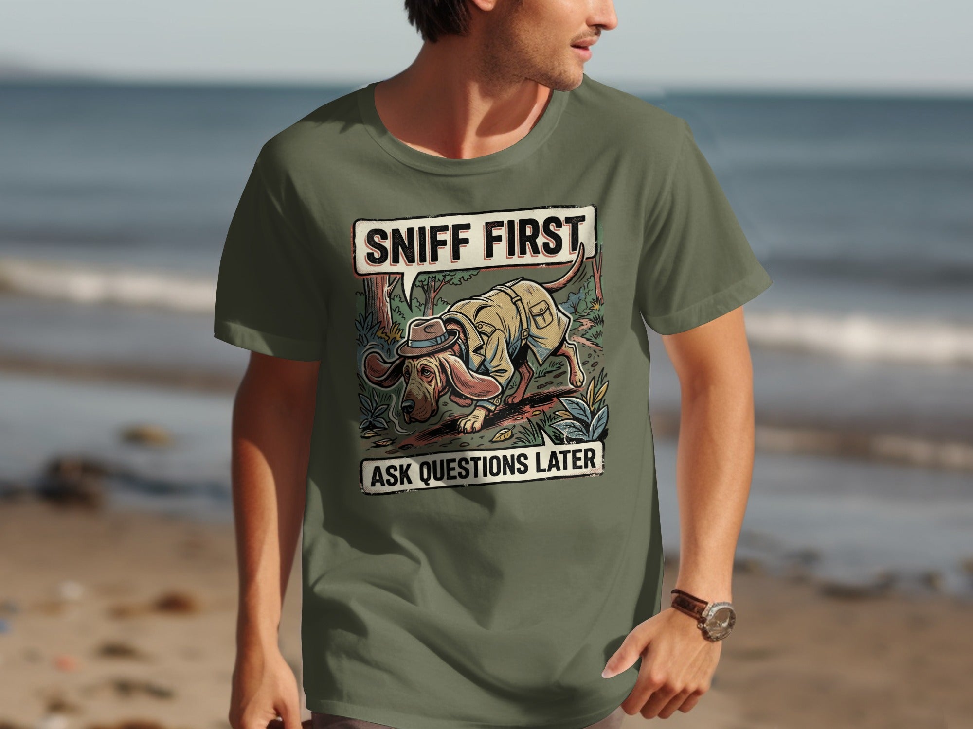 Green t-shirt with graphic of a dog wearing a hat and trench coat, sniffing.