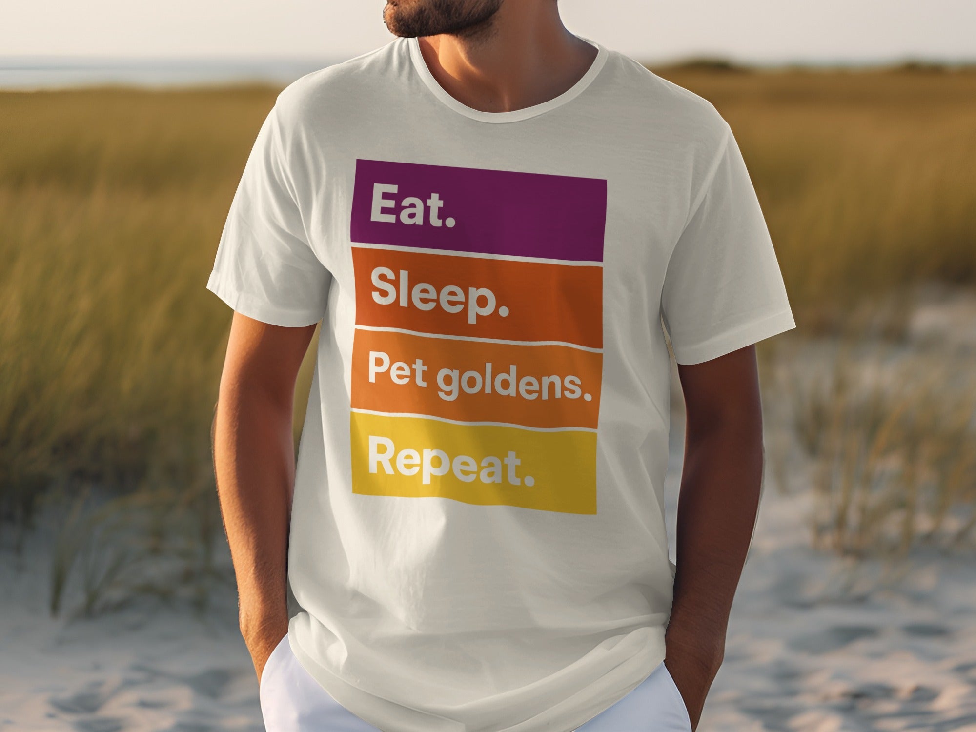 White t-shirt with "Eat. Sleep. Pet goldens. Repeat." text in purple, orange, and yellow.