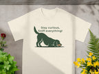 Cream t-shirt with dark green dog illustration and text "Stay curious, Sniff everything!".