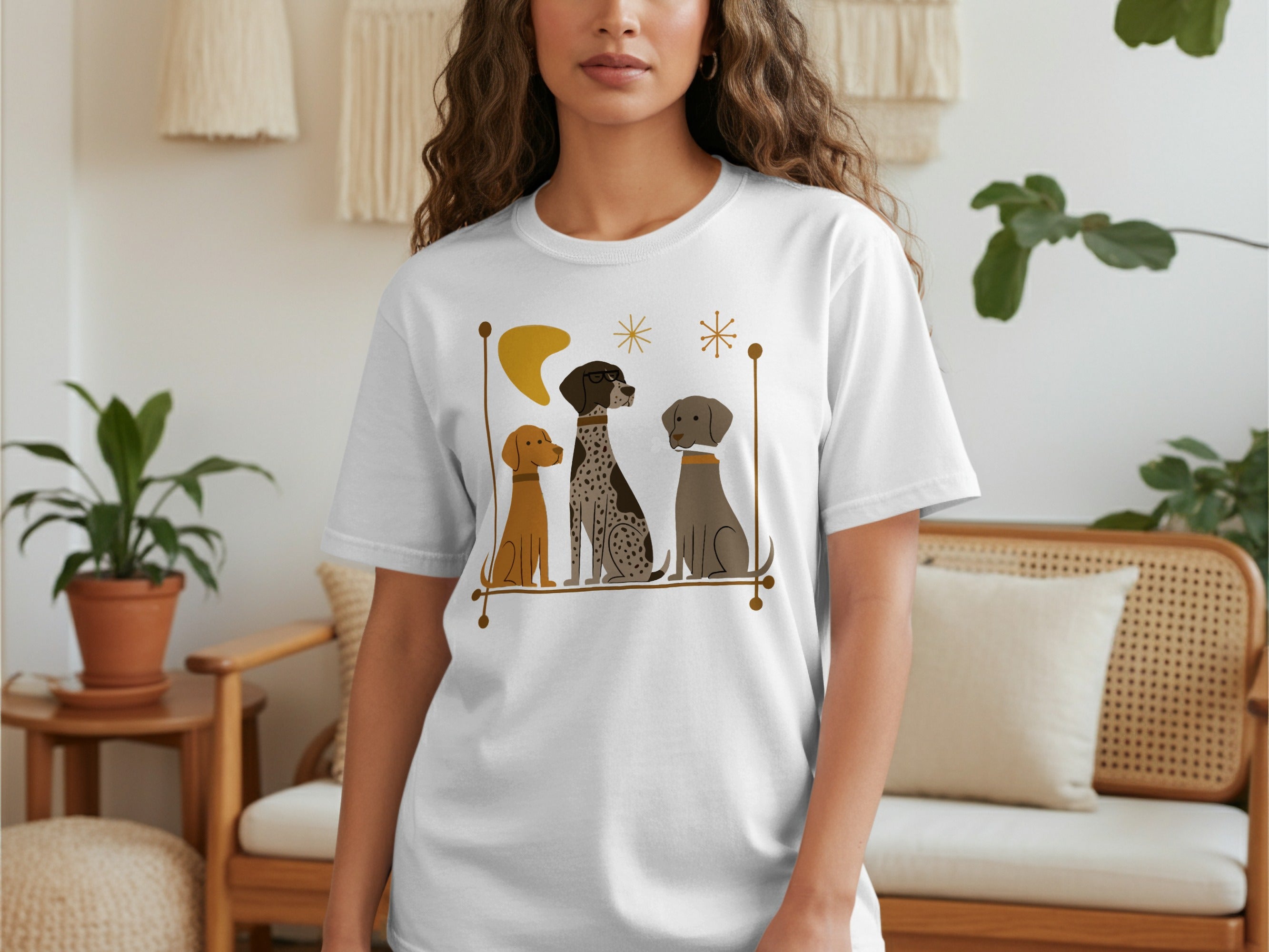 T-shirt featuring three dogs sitting together with abstract decorative elements.