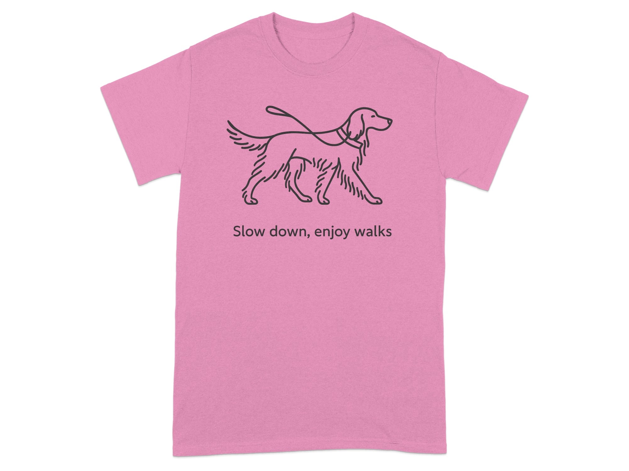Pink t-shirt with a black line drawing of a dog on a leash and the text "Slow down, enjoy walks".