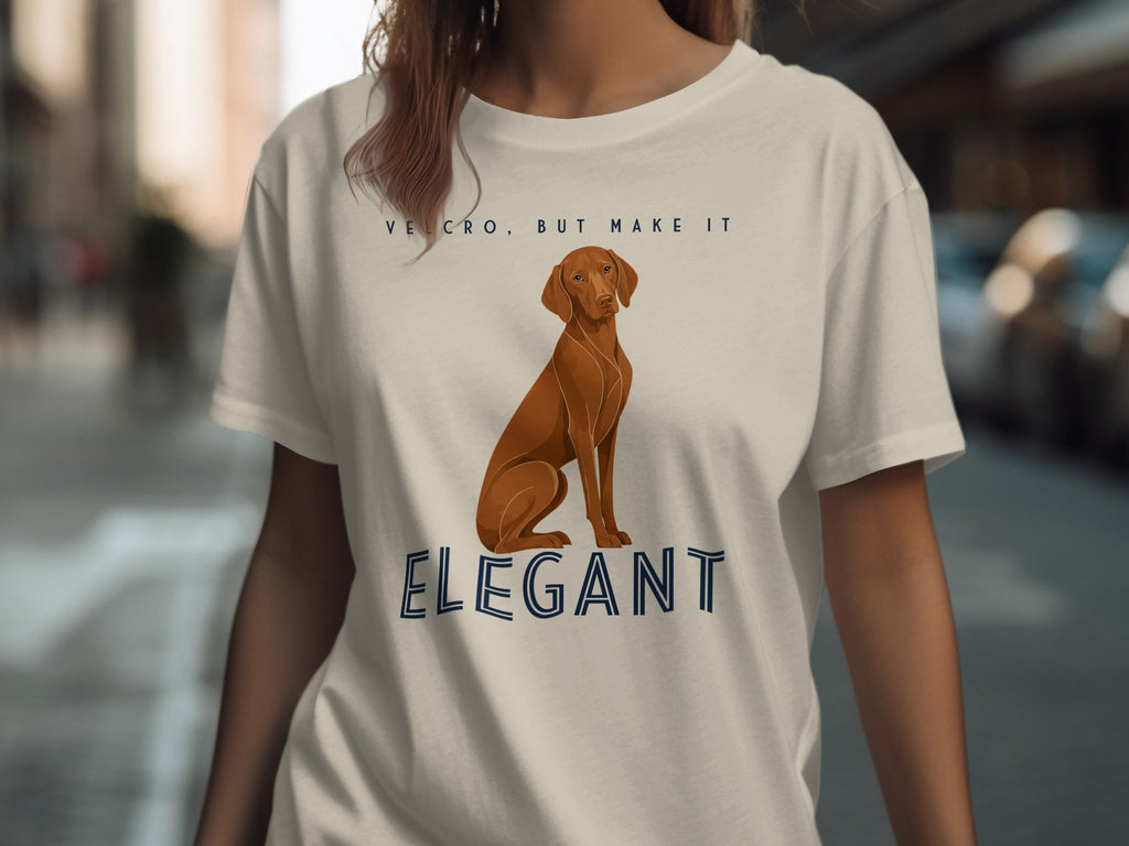 Brown dog sitting on t-shirt with "VELCRO, BUT MAKE IT ELEGANT" text.