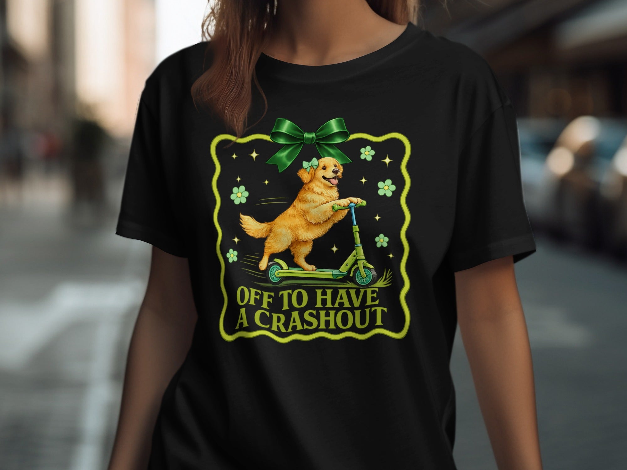Golden retriever on a scooter with green bow and text "OFF TO HAVE A CRASHOUT".